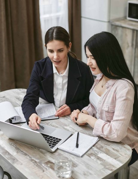 Two office workers looking at a laptop
